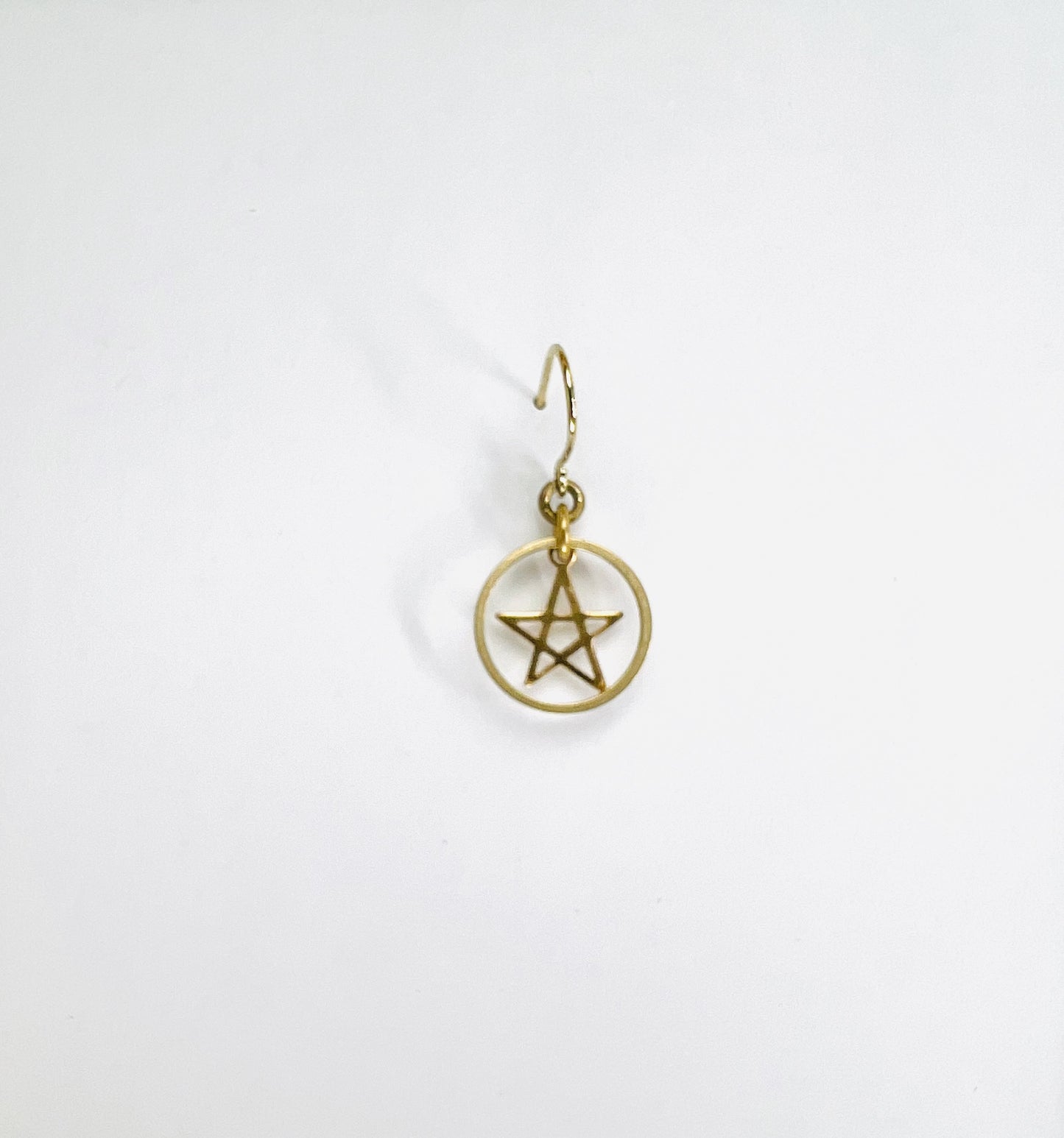 Minimal brass ring and star single earring, handcrafted intentional jewelry designed for everyday wear. Gold pentagram earring on a white background