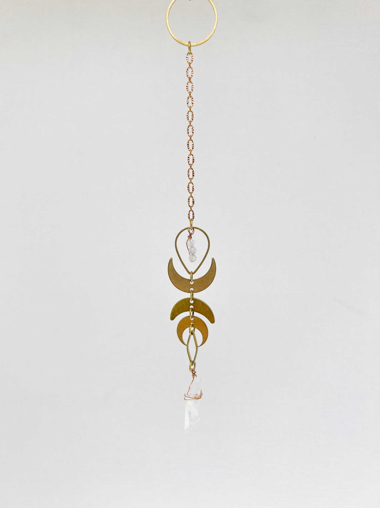Handmade hanging art made of Moonstone, Clear Quartz, metal crescent moons and chain; a spiritual tool or pendulum, designed to support intuition, clarity, energetic alignment, and intentional choice making practices.