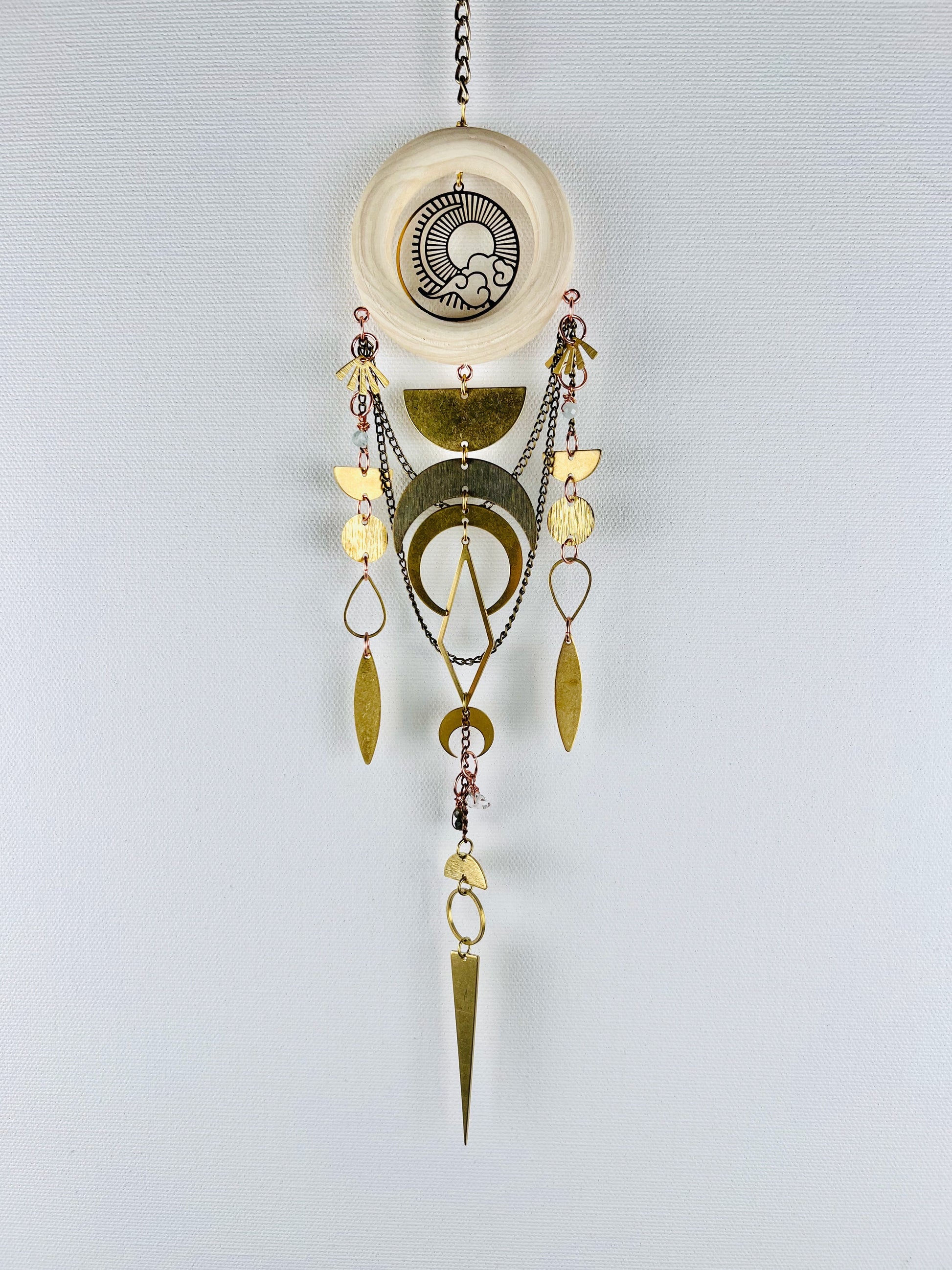 Decorative hanging ornament with gold and silver elements on a light gray background. Handmade Aquamarine, Green Tourmaline, and Herkimer Diamond wall art manifestation charm created for intentional home decor and emotional balance.