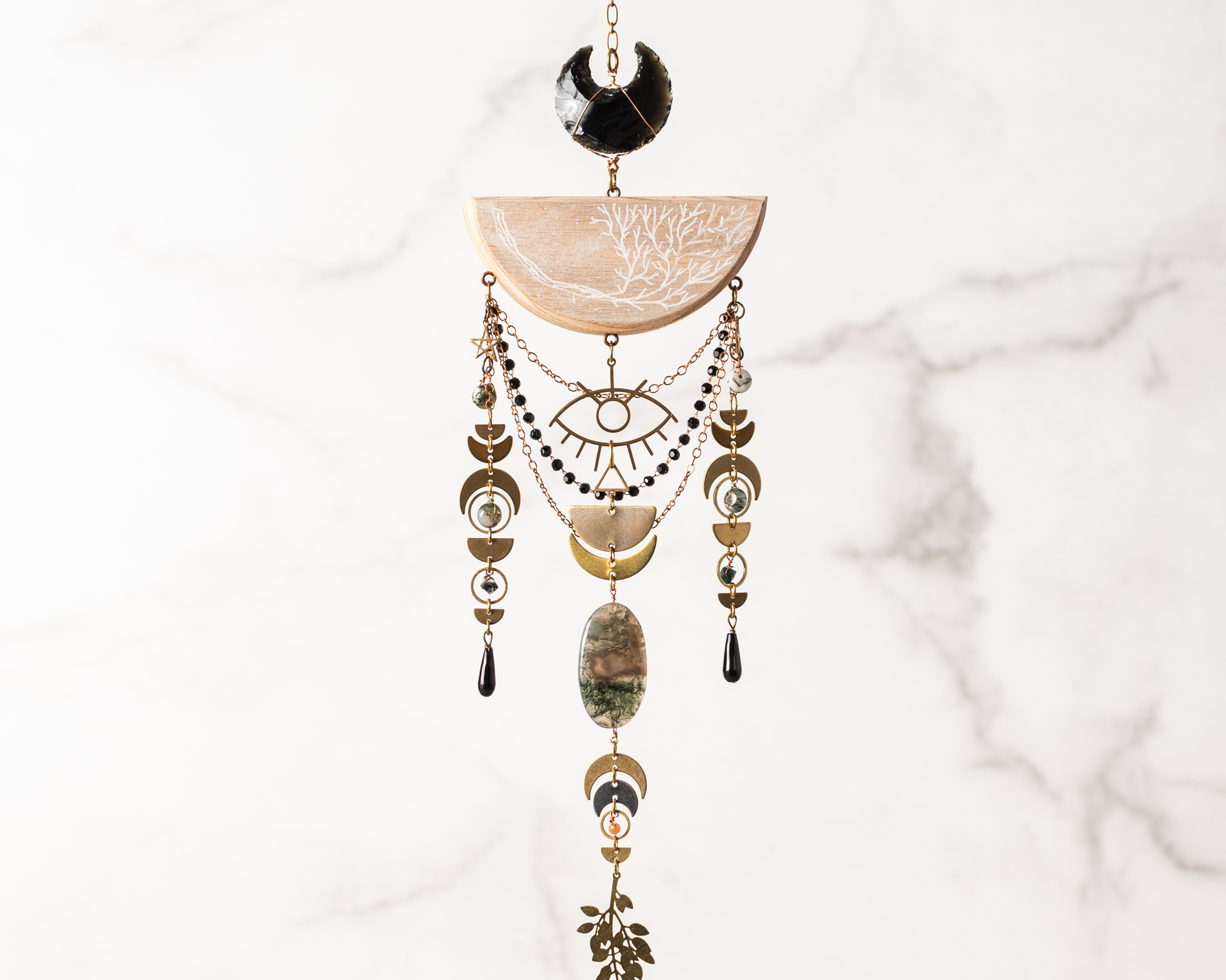 Decorative hanging ornament with beads, crystals and stones on a marble background