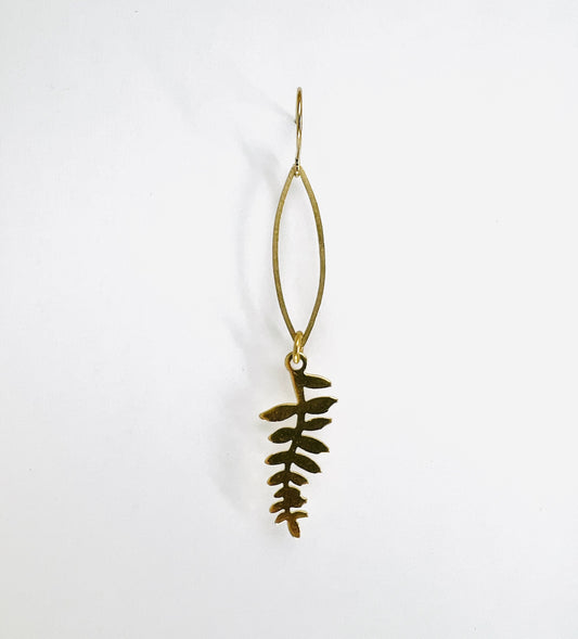 minimalist Fern leaf single gold colored earring, handcrafted nature-inspired, hanging on white background.
