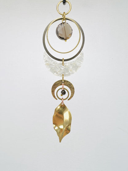 Decorative hanging ornament with gold, acrylic and silver elements on a white background. Handmade Smoky Quartz manifestation mini charm used as a rearview mirror car charm and intentional home decor piece.