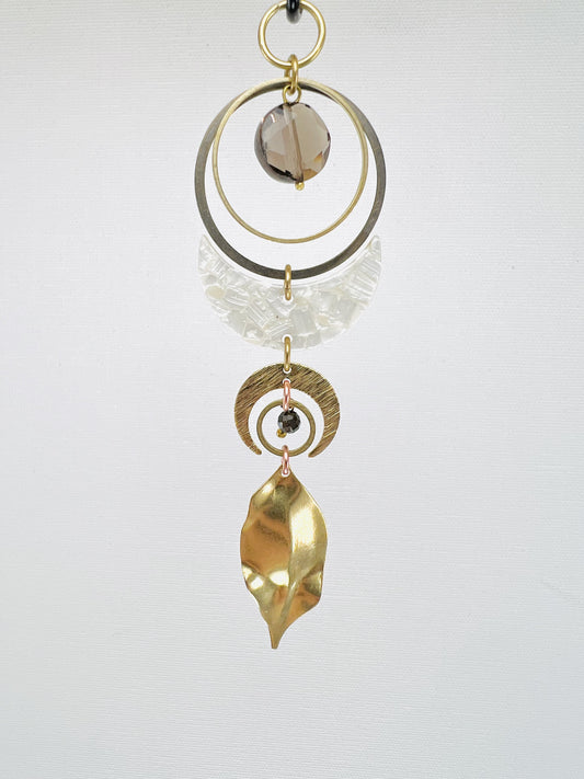 Decorative hanging ornament with gold, acrylic and silver elements on a white background. Handmade Smoky Quartz manifestation mini charm used as a rearview mirror car charm and intentional home decor piece.